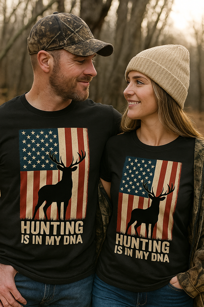 Couple wearing matching ‘Hunting Is In My DNA’ patriotic T-shirts with American flag and deer silhouette design, standing in a fall forest setting.